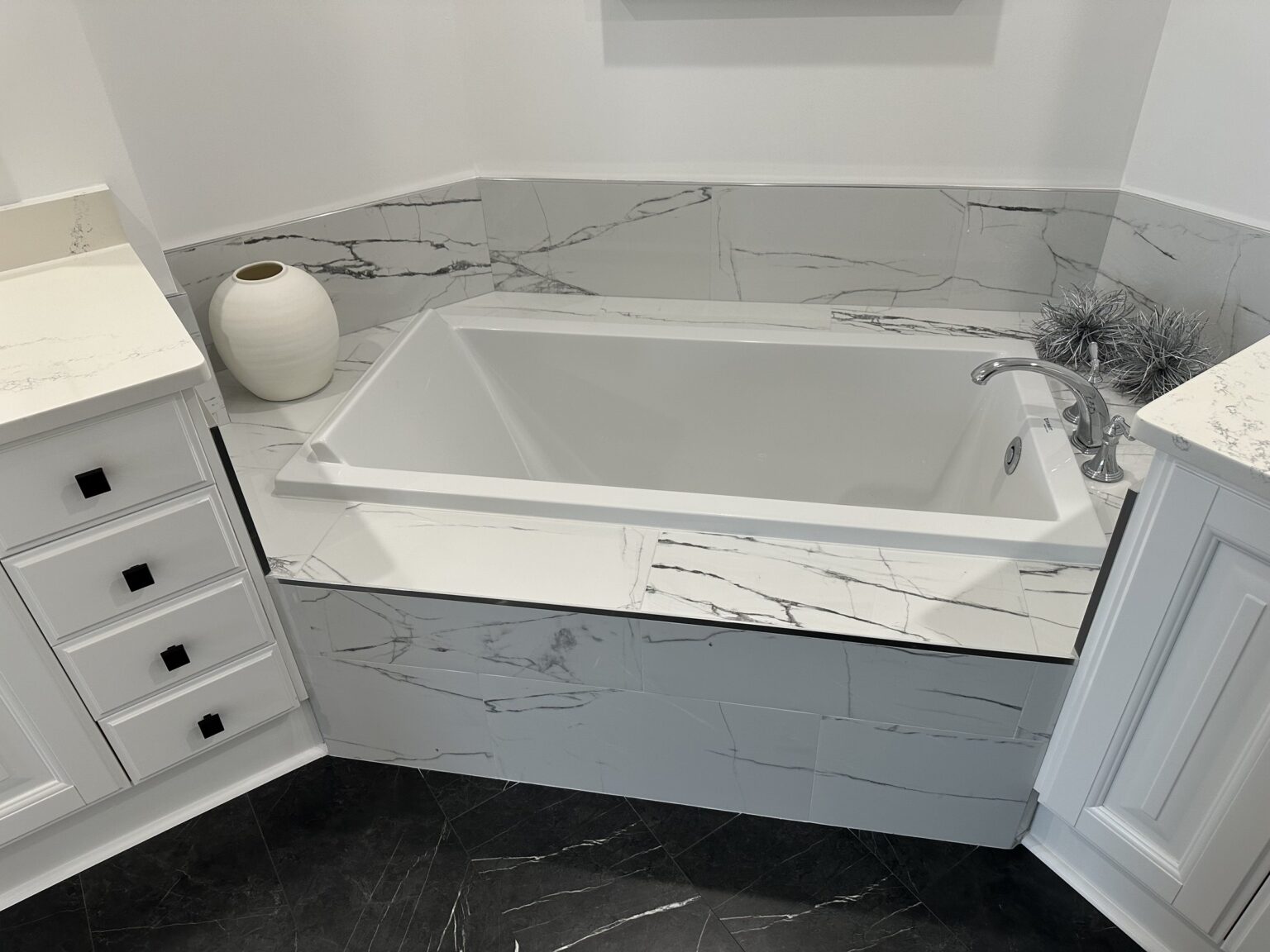 Remodeled bathroom with a freestanding soaking tub and marble surround